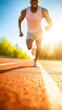 © red_orange_stock - An athlete is sprinting swiftly on a bright track under clear blue skies