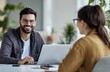 © Sagar - A smiling man and woman sitting at an office desk, using laptops