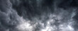 © aFotostock - Banner Dramatic dark storm clouds black sky background. Dark thunderstorm clouds rainny season. Panorama Meteorology danger windstorm disasters climate. Dark cloudscape storm cloud with copy space.