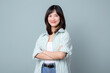 © Jirawatfoto - Happy enterpriser asian woman looking at camera and smile while crossing arm isolated on pastel green background.