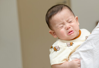 Asian infant crying baby. child tired and hungry 
in mother arms. Children cry. Asia baby screaming. emotion child concepts