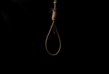 A noose made of rope hanging against a dark background