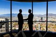 © carles - Business professionals shaking hands in a modern office with city view.