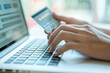 © Sunday Cat Studio - A person is using a laptop to pay for something with a credit card