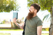 © luismolinero - Redhead man with beard holding a passport at outdoors with happy expression