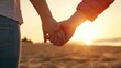 © Alice a. - Two people holding hands on a beach at sunset. Scene is warm and romantic