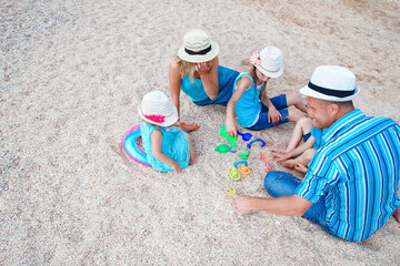 Canvas Print - A Happy family playing by the sea shore on the sand background