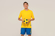 © neonshot - Photo of happy, smiling teen boy in sportswear holding soccer ball and looking at the camera.