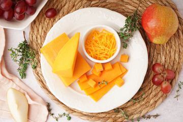 Sticker - Plate with tasty cheddar cheese, herbs, pear and grapes on light background