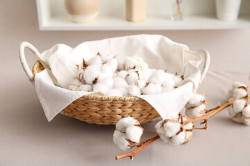 Wall Mural - Basket with cotton flowers with sprig on white table in room