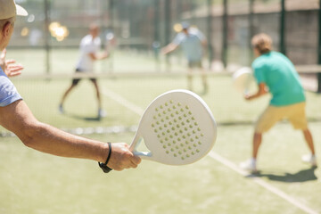 Wall Mural - Men play padel on an outdoor tennis court. Hitting the ball with a racket