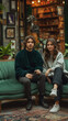 © h3design - A couple sits on a green couch in an artistic café, surrounded by plants and books, enjoying their time together in a warm, inviting atmosphere