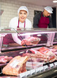 © JackF - Young female butcher showing big piece of beef meat