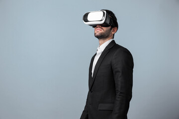 Skilled project manager with VR glasses standing and looking around. Caucasian businessman connecting with metaverse and virtual reality world while wearing suit. Innovation technology. Deviation.