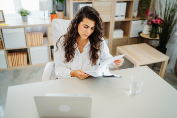 Wall Mural - Young caucasian business woman working in office on laptop