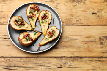 Sticker - Tasty baked pears with nuts, blue cheese, thyme and honey on wooden table, top view. Space for text