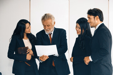 Wall Mural - Senior caucasian manager working in office with assistance of young Asian business people and translator in meeting. Corporate international business and secretary language translation concept. uds