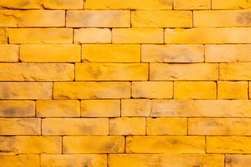 Textured brick blocks in close-up highlighting the rough and weathered appearance. Yellow