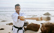 © peopleimages.com - Karate, beach and man with katana for training, practice and learning aikido, taekwondo and jiujitsu. Sports, nature and person with bokken by ocean for fitness, exercise and workout for martial arts
