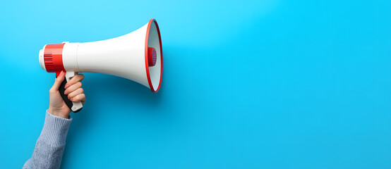 A Person Holding a Megaphone Against a Blue Background with Enthusiastic Expression