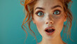 © Creative_Bringer - Surprised woman with wide eyes and open mouth, posing against a bright blue background