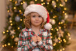 © Volodymyr - Kid boy in santa hat near christmas tree at home.