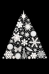 Wall Mural - Christmas tree fantasy concept shape with white frosted decorations on black background. Surreal design with snowflake, star, pine cone, butterfly ornaments.