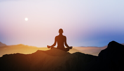 Backlit person in yoga pose on bright sunset background with mock up place. Calmness concept.