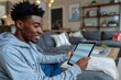 © Yuliia - Beautiful African American man using his digital tablet to manage his schedule at home.