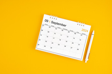 September 2024, Monthly desk calendar for 2024 year and pen on yellow background.