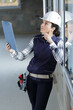 © auremar - female construction worker on site holding clipboard