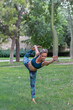 © ADDICTIVE STOCK CORE - Calm woman performing Standing Bow pose in green park