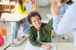 © Home-stock - Female teacher giving high five to Latin schoolboy sitting at desk, supporting kid, achievement, success and mentorship for learning