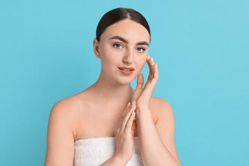 Poster - Beautiful young woman with healthy skin on light blue background