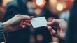 © doraclub - A close-up of two hands exchanging a blank business card, symbolizing networking and professional connections.