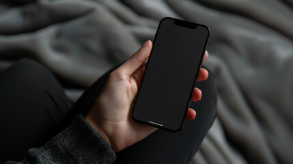 Wall Mural - Close-up of a modern smartphone in hands on a gray plaid background. Black technology phone indoors. Concept of technology, modernity.