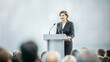 © N7 - Female Politician at Conference Podium - A woman politician addressing the audience from a conference podium.