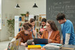 © Mediaphotos - Colorful portrait of diverse group of children talking to female teacher during computer class in school library copy space