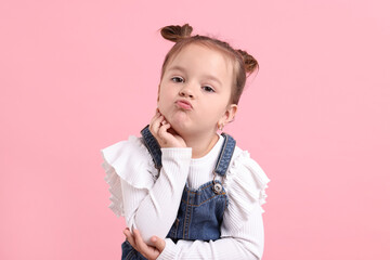 Wall Mural - Portrait of cute little girl on pink background