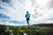 © lzf - Fitness woman runner running at flowering grassland mountain top