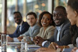 © 92ashrafsoomro - Diverse business professionals smile during a seated indoor meeting presentation in a bright office.