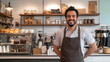 © Tiravad - A handsome barista smiles confidently behind the counter of his cafe, with pastries and coffee equipment displayed in the background.