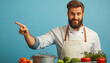 © ЮРИЙ ПОЗДНИКОВ - Happy chef pointing aside to copy space standing at desk with vegetables