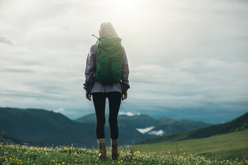 Wall Mural - Woman hiker on beautiful flowering grassland mountain top