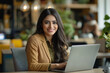 © Natali - Happy latin hispanic young business woman working on laptop computer in company office. Smiling Indian entrepreneur manager businesswoman using pc for communication, learning at workplace