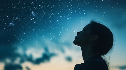 A woman is looking up at the stars in the sky
