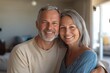 © Vladislav - Middle-aged couple hugging each other in living room, smiling and looking at camera. Minimalist interior design with modern furniture and decor in the background.