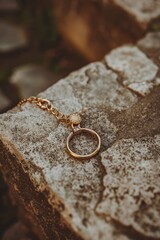 Sticker - A gold wedding ring sits atop a stone wall, perfect for use in wedding or engagement photoshoots