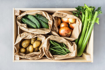 Wall Mural - Fresh organic vegetables in a wooden box. Crate with celery, onions, potatoes, cucumbers and green beans. Top view