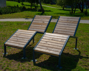 two wooden deckchairs against a background of green grass